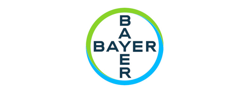 Das Bayer-Logo zeigt das Wort 'BAYER' in fetten Buchstaben, umgeben von einem lebhaften grünen und blauen kreisförmigen Design.